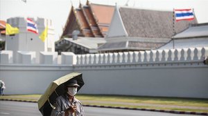 បុរសម្នាក់ ដើរពីខាងមុខព្រះបរមរាជវាំង ប្រទេសថៃ