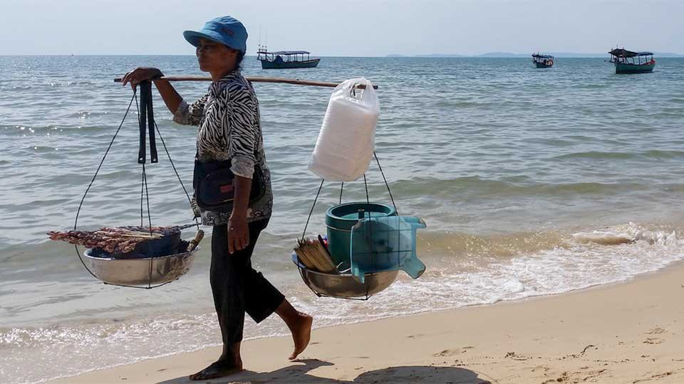 ស្ត្រីខ្មែរ​ដើរលក់​ចំណី​ឲ្យ​ភ្ញៀវទេសចរ​នៅ​តាម​ឆ្នេរ​ខ្សាច់​ខេត្ត​ព្រះសីហនុ។ រូបភាព៖ Pixabay